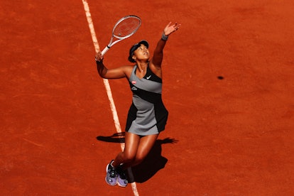 Naomi Osaka of Japan serves in her First Round match against Patricia Maria Tig of Romania during Da...