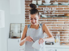 Young woman making TikTok's oven baked pasta recipes in her kitchen.