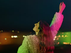 Young woman looking out over the city on her 29th birthday before posting on Instagram with a 29th b...