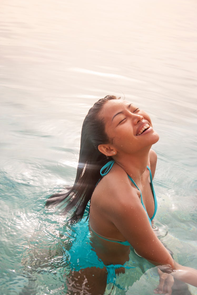 Smiling young woman soaking up the sun's rays, having the best week of August 9, 2021, per her zodia...