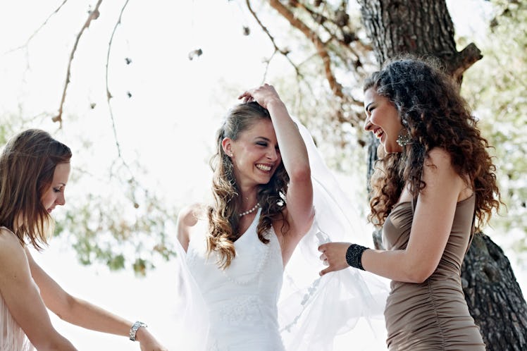 Young bride dancing with her bridesmaids before posting a pic on Instagram with wedding captions.