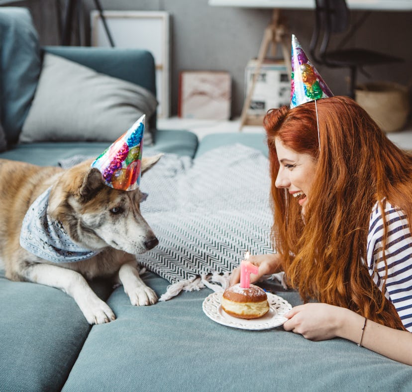 Young woman celebrating her puppy's birthday with a cake and dog birthday Instagram captions.