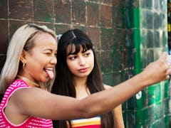 2 young women taking a fun selfie before posting on Instagram with birthday captions for best friend...