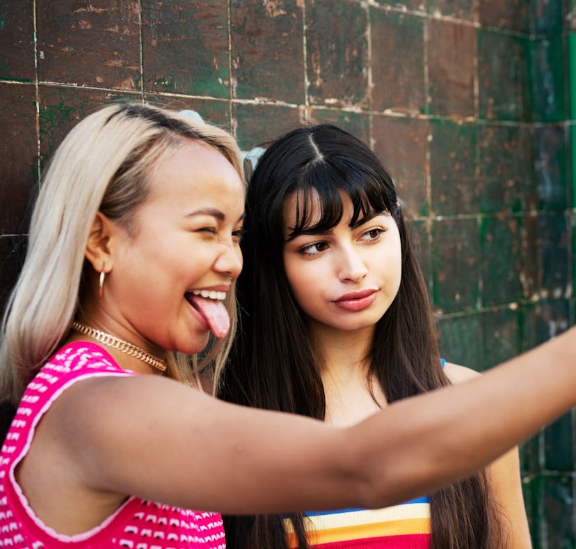 2 young women taking a fun selfie before posting on Instagram with birthday captions for best friend...