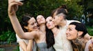 Bridesmaids taking a selfie with the brides before posting a pic on Instagram with wedding captions.