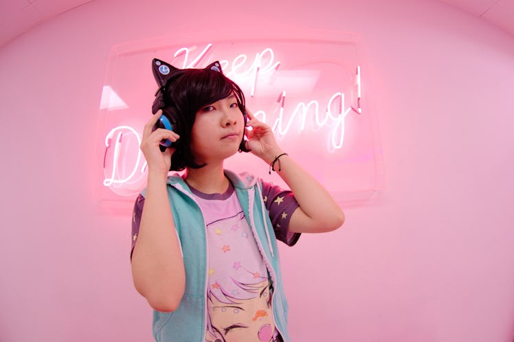 e.l.f.'s Game Up Contest winner Wren in an all-pink room anime shirt, and cat-eared headphones.