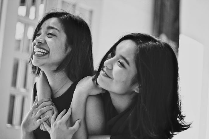 black and white photo of two sisters hugging and smiling