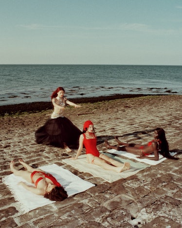 Three women in red swimwear sets and a woman in a sequin bikini and black skirt by Dilara Findikoglu