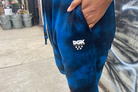 A closeup of the sweatpants showing a hand in the pocket, where a DGK logo is printed