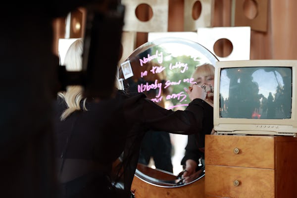 Billie Eilish writes on a mirror at her Spotify-hosted album launch party, 'Happier Than Ever: The D...