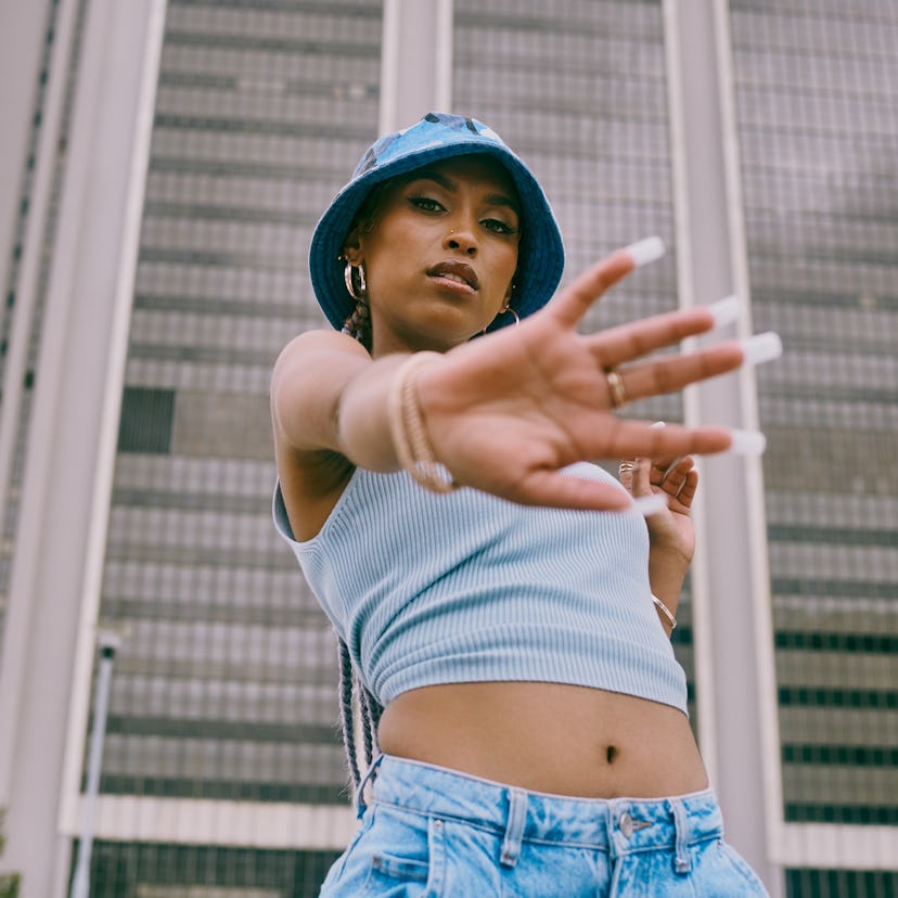 A young woman giving "the hand" to the camera with a blue hat to showing the meaning of a new moon.