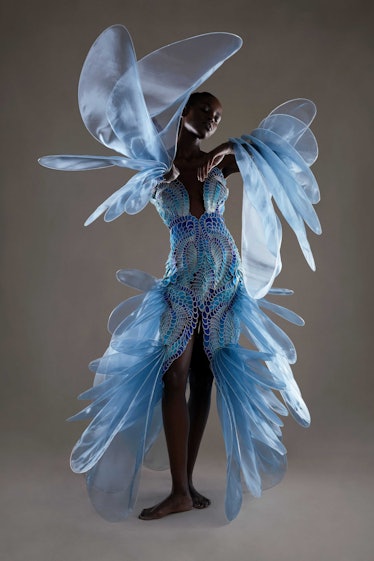 A model in a light blue Iris Van Herpen crochet-looking dress with large ruffles down the sides 