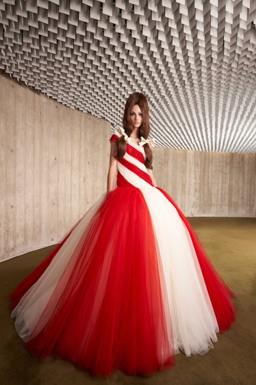 A model in a red and white tulle Giambattista Valli gown and pigtails with bows in them 