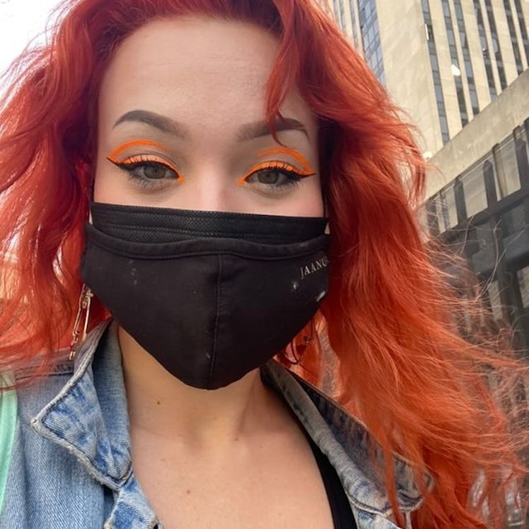 Hayley Adams in a neon orange, graphic eyeliner design using skills she honed for her post-pandemic ...