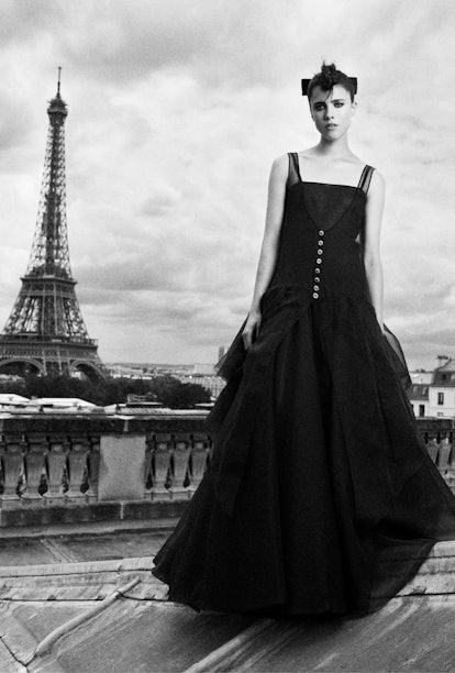 Margaret Qualley, wearing Chanel couture, standing in front of the Eiffel Tower