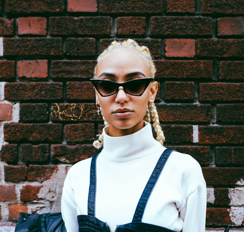 Self-confident young woman wearing sunglasses, ready to post a pic on Instagram with a shady caption...