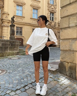 Influencer THANYAW wears black bike shorts in 2021, paired with an oversize white tee and chunky New...