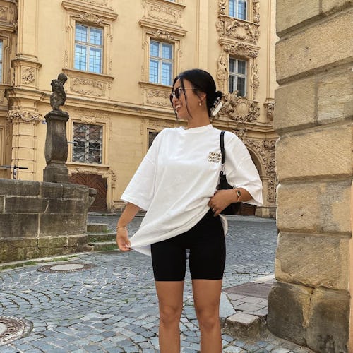 Influencer THANYAW wears black bike shorts in 2021, paired with an oversize white tee and chunky New...