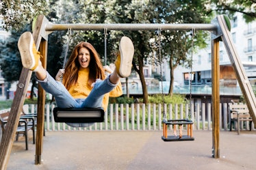 Young Cancer woman smiling while on a swing.