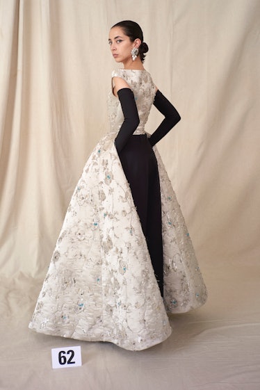 A model in a white flower-patterned gown with a black back and gloves from Balenciaga Couture Fall 2...