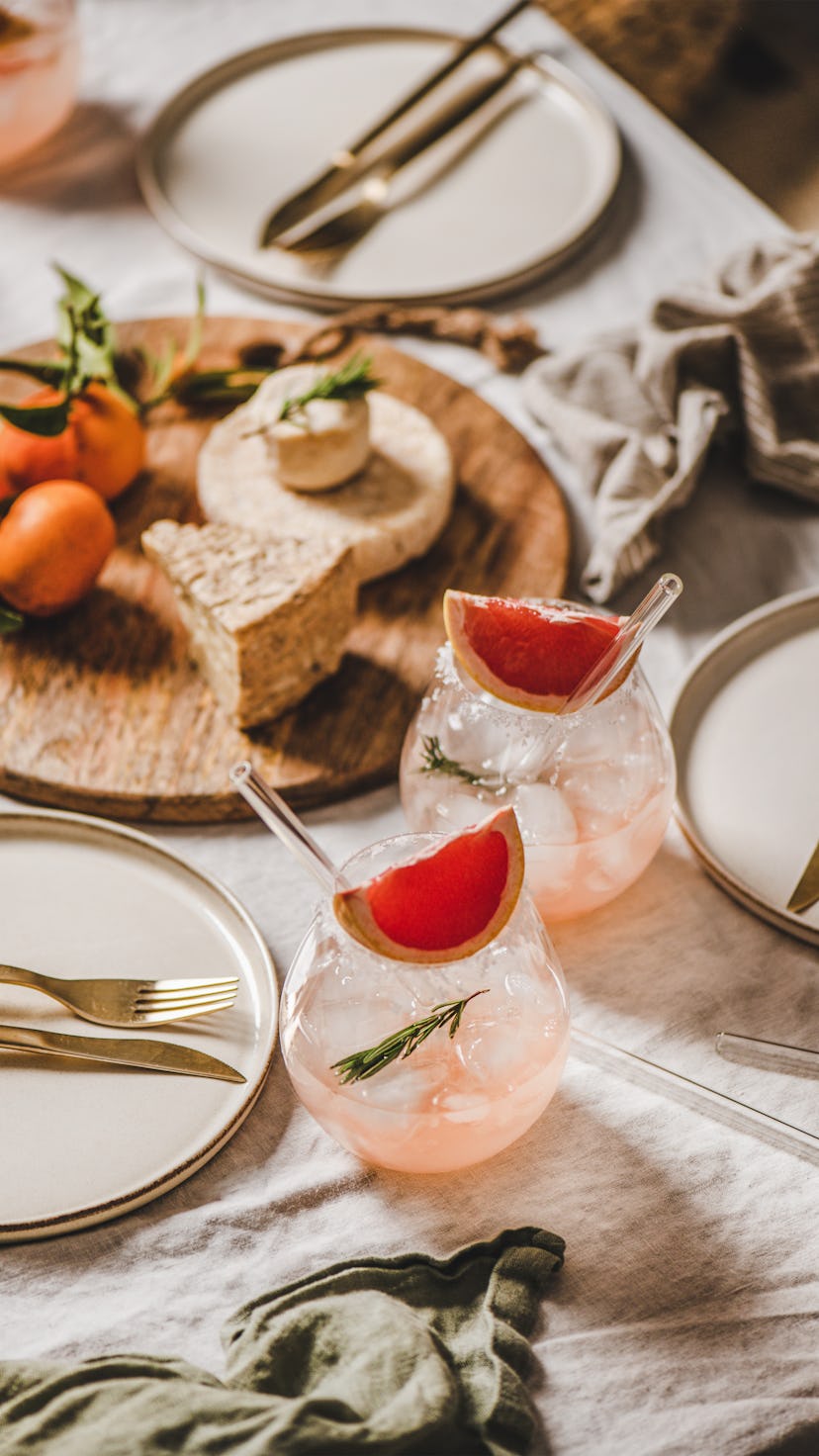 Two cocktails paired with an assortment of cheeses for a dinner party.