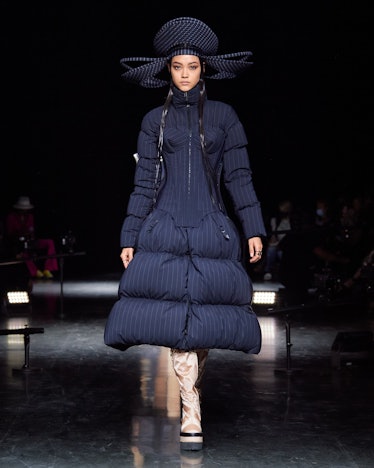 A model walking the runway in a Jean Paul Gaultier blue puffer dress and a matching head piece 