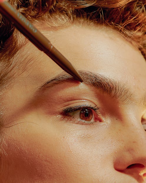 Woman applying eyebrow pencil