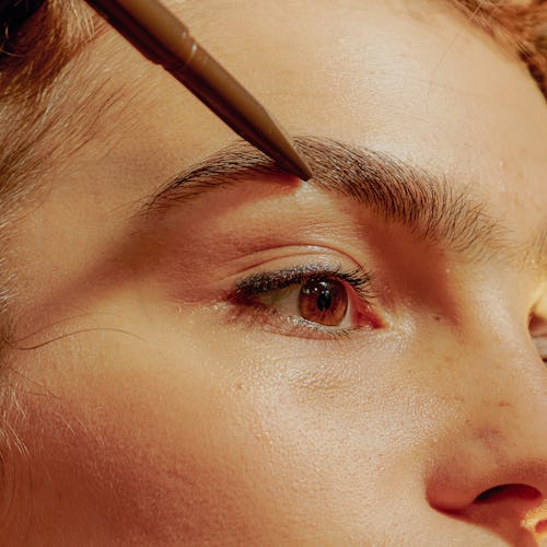 Woman applying eyebrow pencil