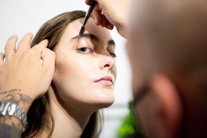 Model getting brows groomed backstage