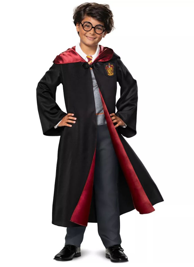 Little boy, posing, wearing Harry Potter costume.