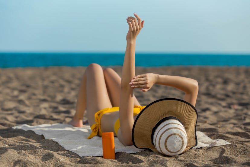Woman on beach using sunscreen
