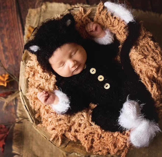 Newborn wearing black cat costume. 