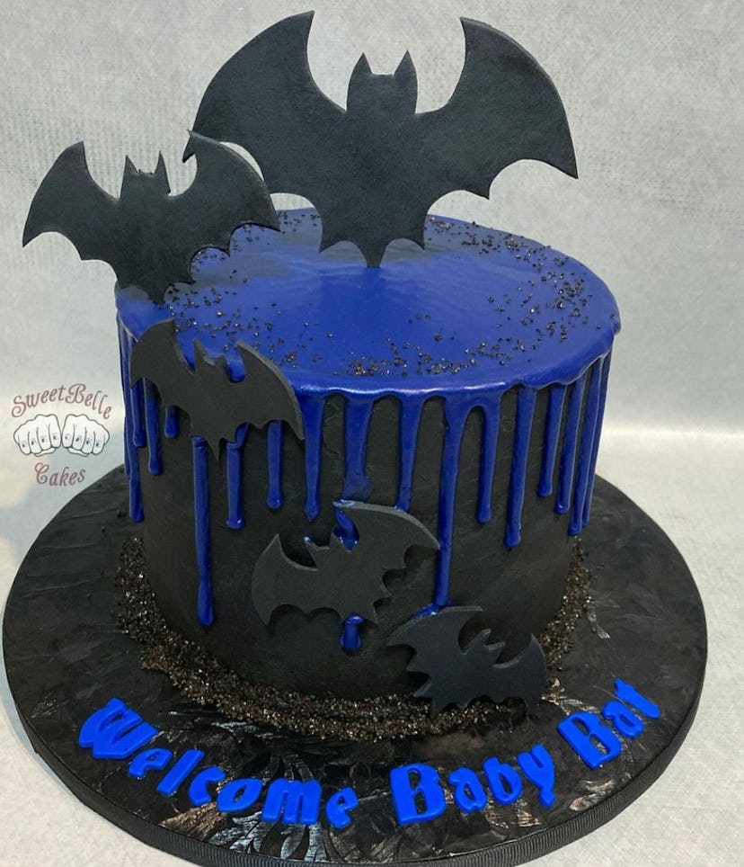 Black cake with blue icing, black bats, and "welcome baby bat" written in blue