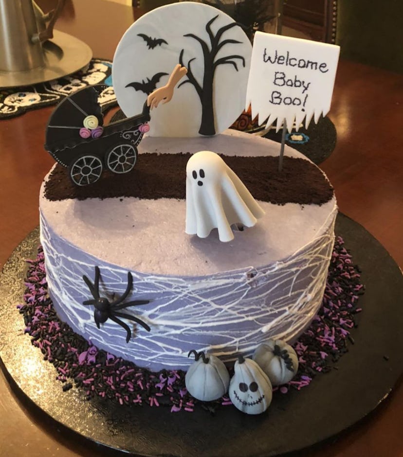 Halloween-themed baby shower cake with carriage, ghost, full moon, spiders and spider webs