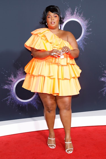 Lizzo in Orange dress with tiny purse. 