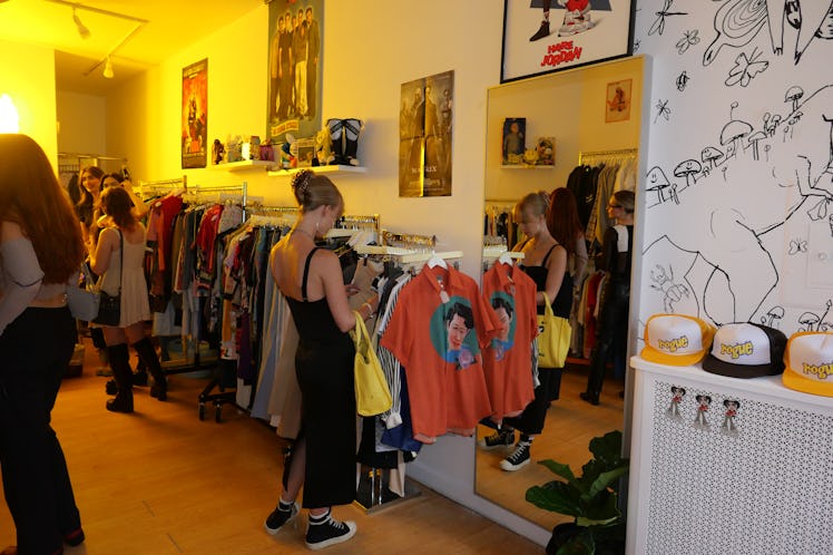 A blonde woman in a long black dress and sneakers browses racks of vintage clothing at Rogue in New ...