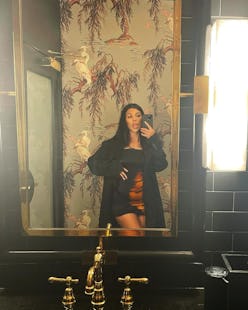 Kourtney Kardashian wears silky slip dress from MSBHV while posing for a mirror selfie on Instagram.