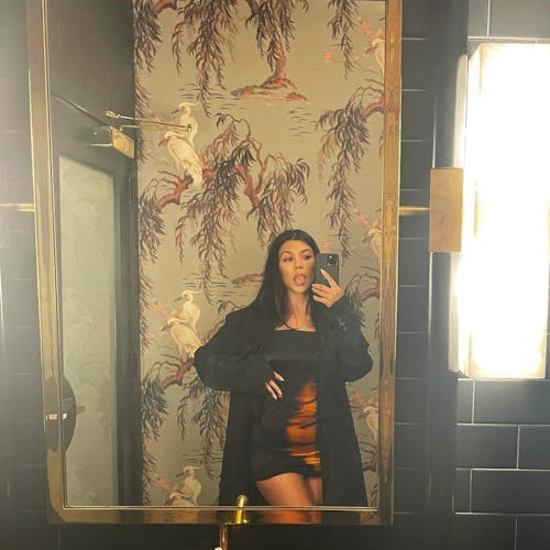 Kourtney Kardashian wears silky slip dress from MSBHV while posing for a mirror selfie on Instagram.