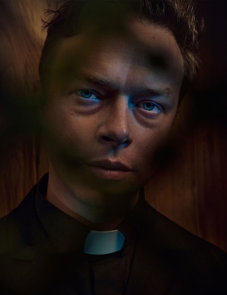 A portrait of Dane DeHaan dressed as a priest