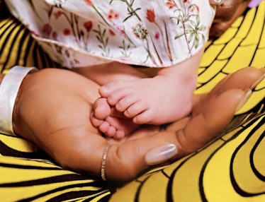 A close up of Supermodel and mom Naomi Campbell’s hand holding daughter’s feet.