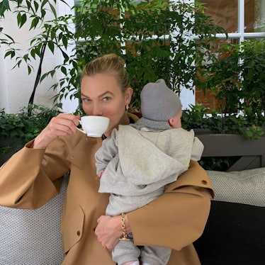 Karlie Kloss, a mom and supermodel drinking coffee while holding her daughter.