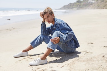 Hailey Bieber wearing sneakers and denim on the beach