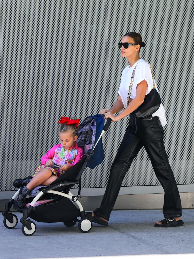 Mom supermodel Irina Shayk walking with her daughter in the stroller.