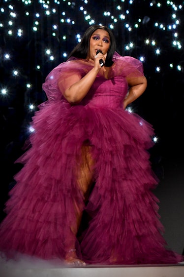 Lizzo performing in a burgundy gown. 