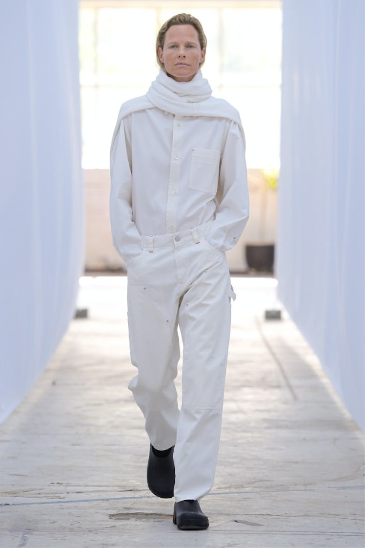 A model walking in a white button-up, jeans and scarf from Berner Kühl