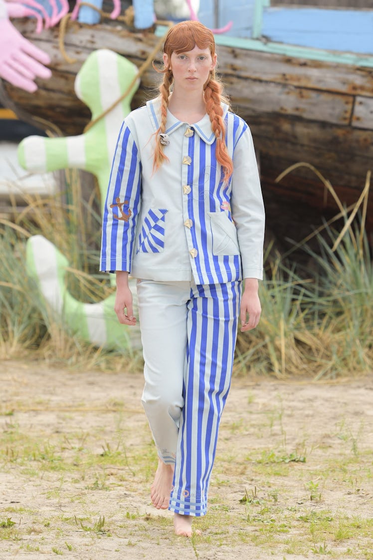 A model in a white and blue striped matching shirt and pants set by Helmstedt