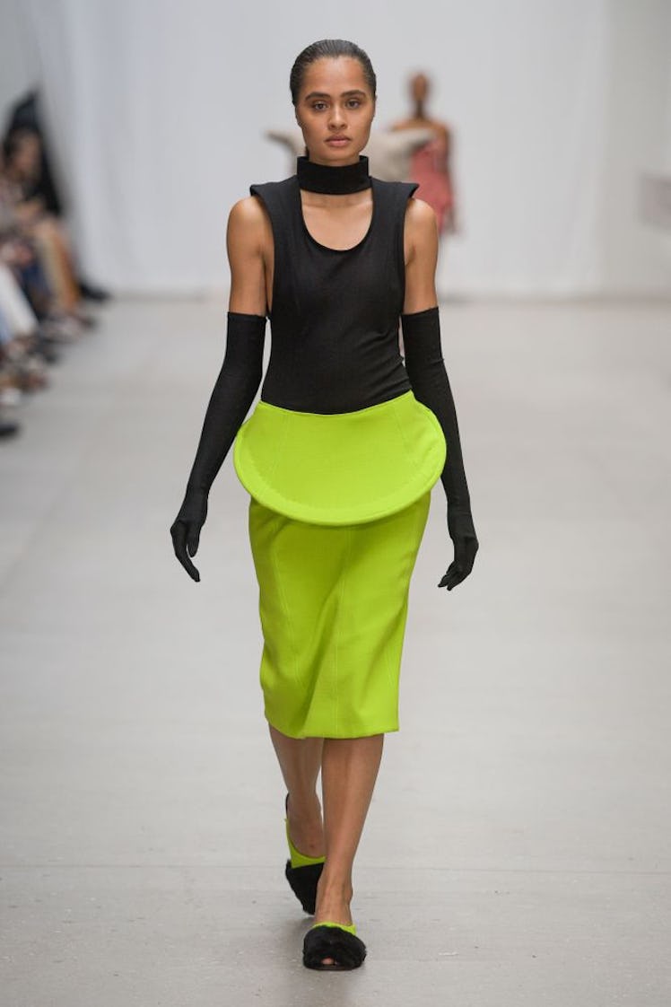 A model walking in an Emilie Axters black top and lime green skirt 
