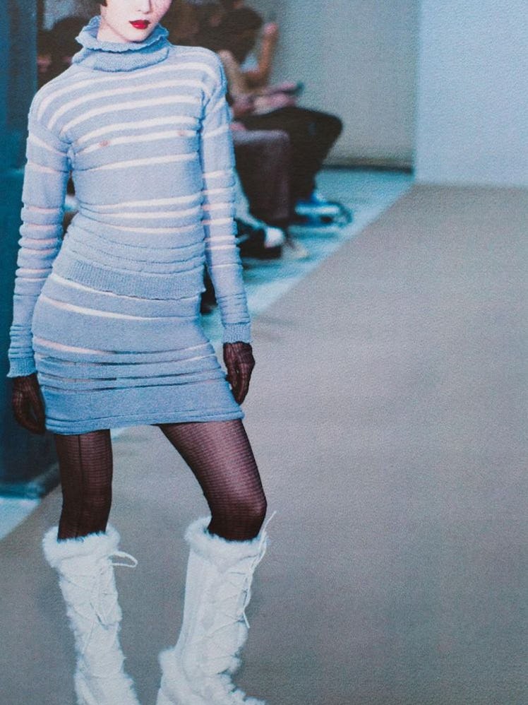 A model in a blue and white striped dress and white boots from Louise Lyngh Bjerregaard