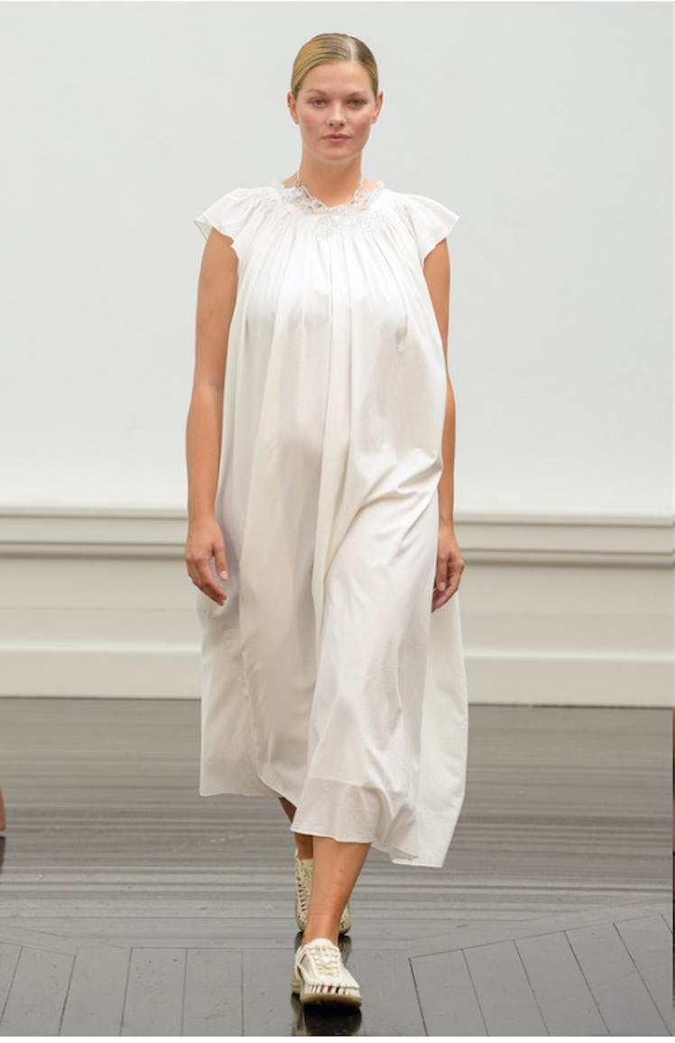 A model walking in a white dress and white loafers by Skall Studio