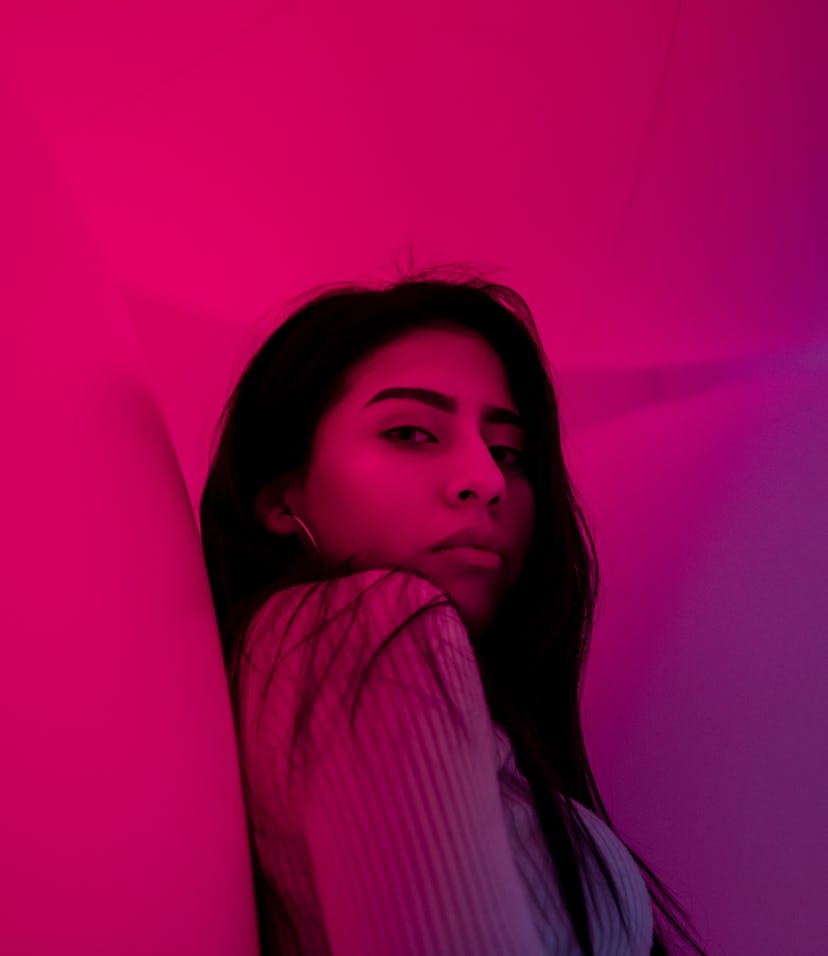 Young woman in pink neon light during Uranus retrograde 2021.